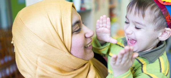 Woman laughing with her son, who is clapping Woman laughing with her son, who is clapping