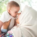 woman touching noses with baby