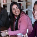 Women laughing with hot drinks