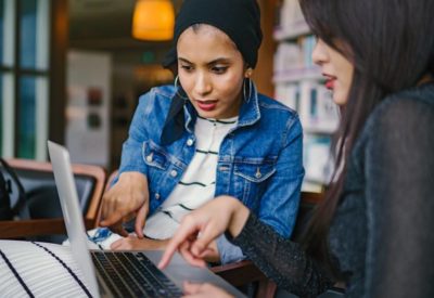 Two women searching on a laptop