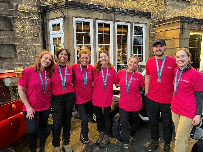 A group of people smiling with their medals after fundraising for Women's Aid.