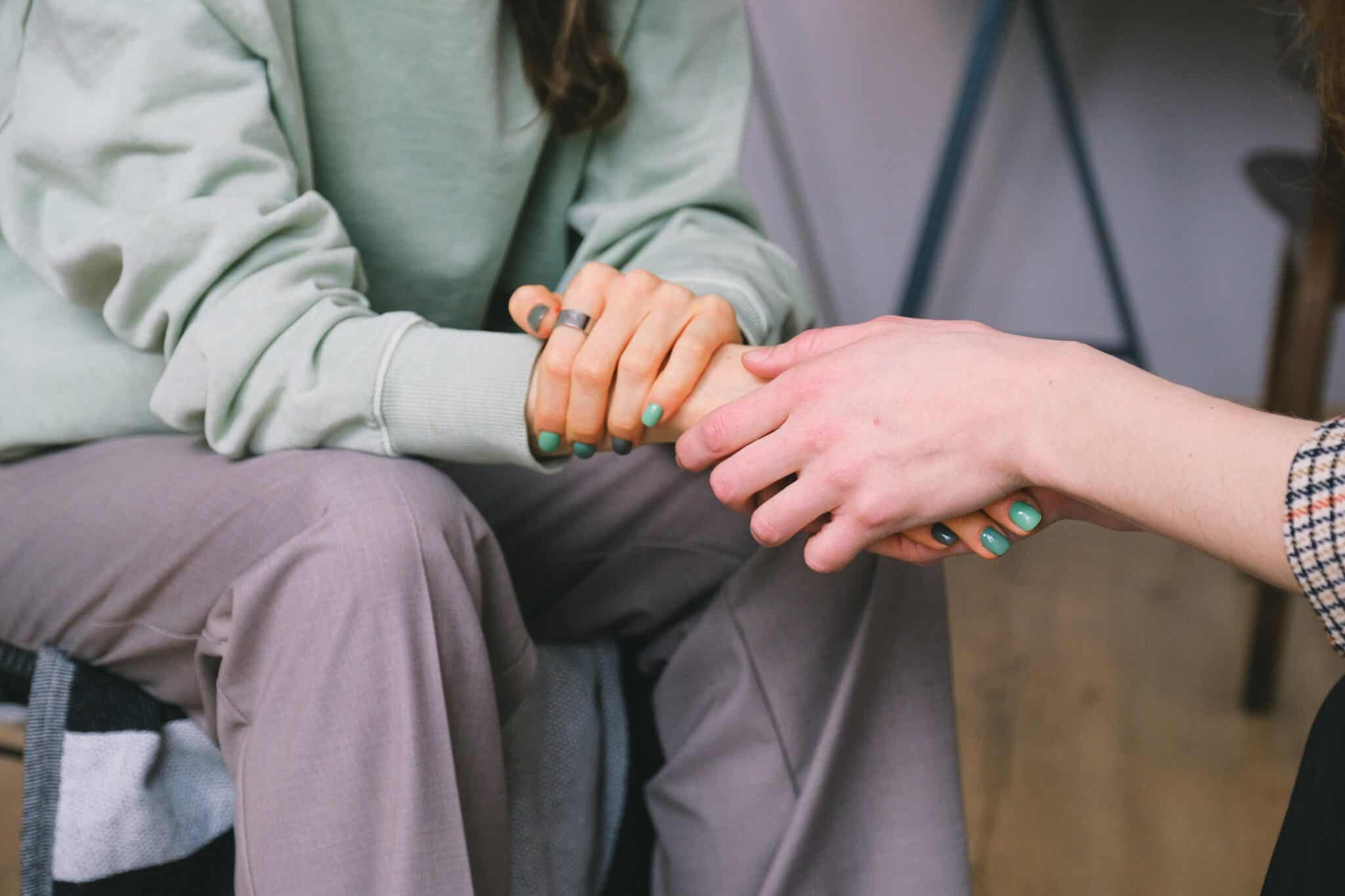 Women holding friend's hand